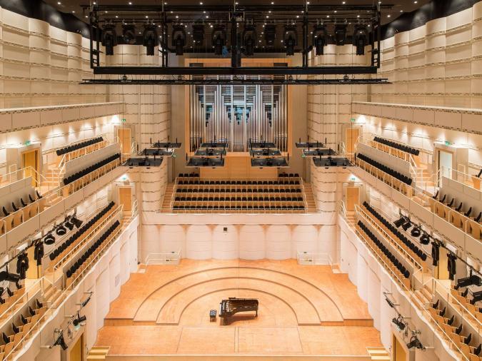 Blick von den Rängen in rechteckigen Konzertsaal mit Konzertflügel und Orgel