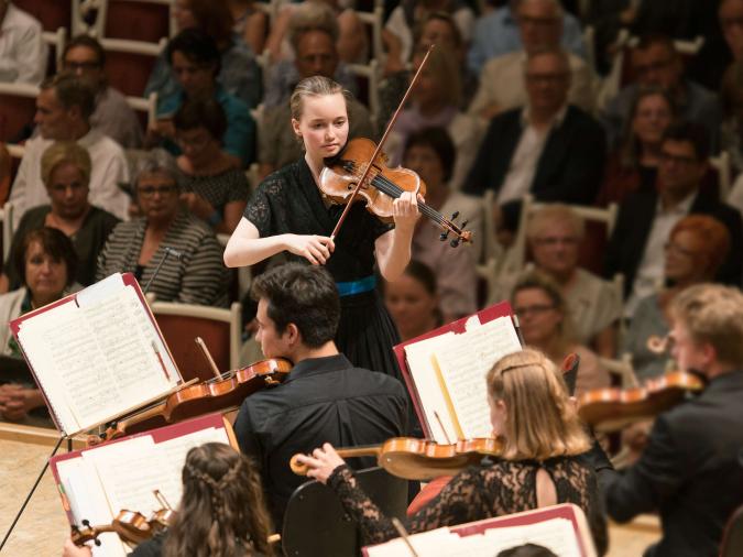 Streicherphilharmonie des VdM: Junge Konzertmeisterin dreht sich zu Orchester während eines Konzerts