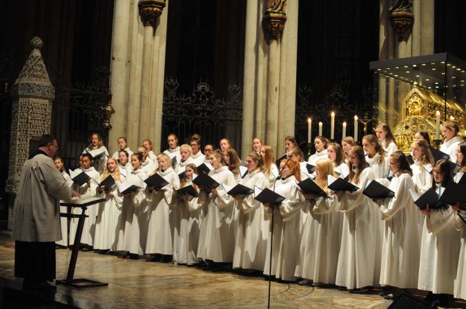 Der Mädchen Chor des Kölner Doms in weißen Roben bei einem Konzert. Er widmet sich insbesondere der zeitgenössischen geistlichen Chormusik.