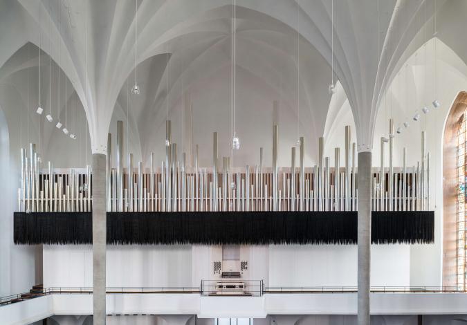 Die neue Orgel in St. Martin Kassel wurde 2017 eingeweiht. Diine Orgelpfeiffen nehmen eine ganze Wand in der weißen Kirche ein. Eine gestalterische Besonderheit sind die schwarzen Kunststofffäden, die den Klang visualisieren. 