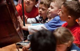 Kinder bewundern ein Cello beim Kinderkonzert der Berliner Philharmoniker