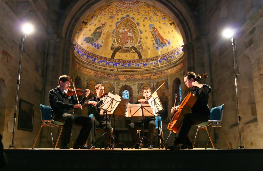 Ein Streichquartett spielt in einer byzantinischen Kirche. 