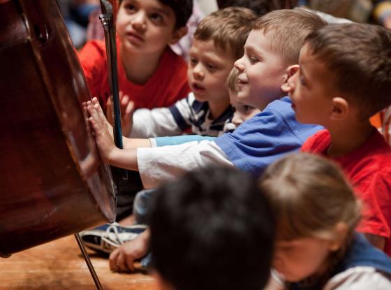 Kinder bewundern ein Cello beim Kinderkonzert der Berliner Philharmoniker